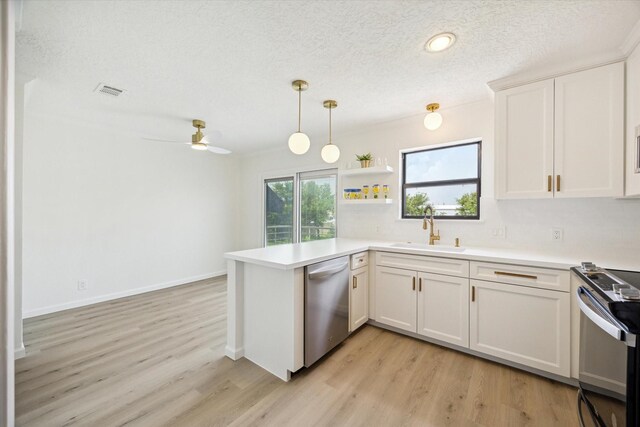 33 Lakewood Ln, Seabrook, TX 77586 - kitchen with dishwasher, electric range oven, a peninsula, light wood-style flooring, and a textured ceiling