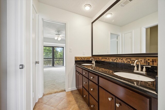 33 Lakewood Ln, Seabrook, TX 77586 - bathroom with double vanity, tasteful backsplash, tile patterned flooring, ceiling fan, and a textured ceiling