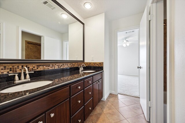 33 Lakewood Ln, Seabrook, TX 77586 - bathroom with double vanity, backsplash, a ceiling fan, tile patterned floors, and a textured ceiling