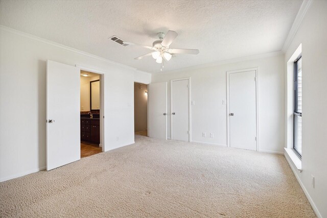 33 Lakewood Ln, Seabrook, TX 77586 - unfurnished bedroom with crown molding, multiple closets, carpet floors, a textured ceiling, and ensuite bathroom