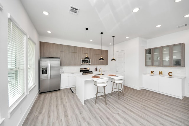 3602 Runnels St, Houston, TX 77003 - kitchen featuring stainless steel appliances, a kitchen bar, light wood-style flooring, modern cabinets, and backsplash