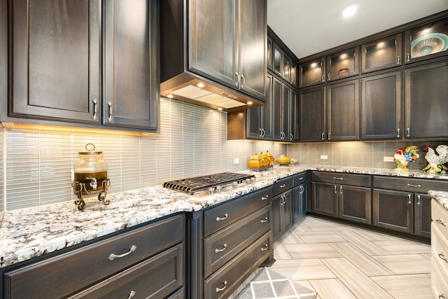 17023 Sweet Bay Ct, Conroe, TX 77385 - kitchen featuring stainless steel gas cooktop, decorative backsplash, and light stone counters