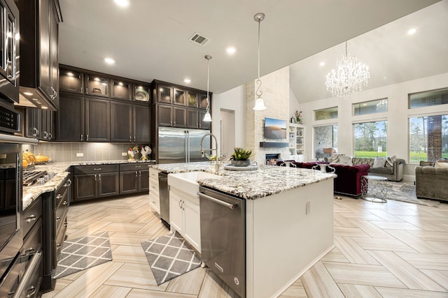 17023 Sweet Bay Ct, Conroe, TX 77385 - kitchen with stainless steel appliances, open floor plan, high vaulted ceiling, glass insert cabinets, and tasteful backsplash