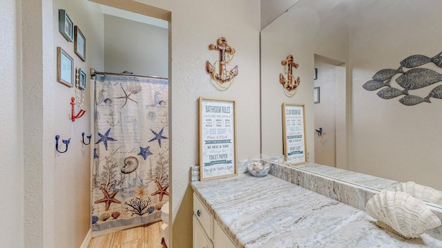 7475 Wooded Creek Dr, Beaumont, TX 77708 - full bath with vanity, wood finished floors, and a shower with shower curtain