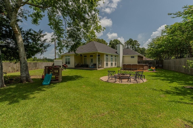 7475 Wooded Creek Dr, Beaumont, TX 77708 - fenced backyard featuring a fire pit, a jacuzzi, and a patio