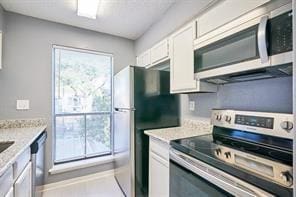 3724 Woodchase Dr, Houston, TX 77042 - kitchen featuring appliances with stainless steel finishes and white cabinets
