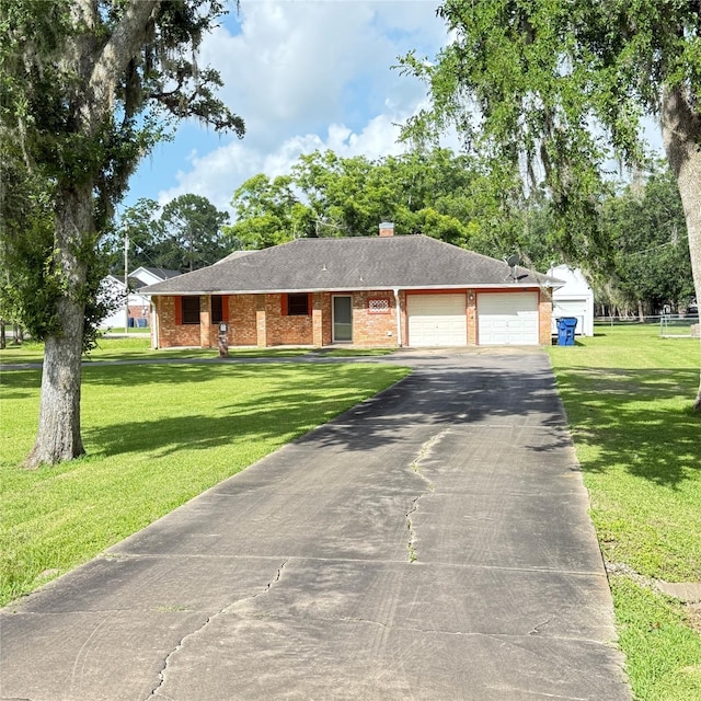 1410 S Dance Dr, West Columbia, TX 77486 - single story home with asphalt driveway, brick siding, an attached garage, and a front lawn