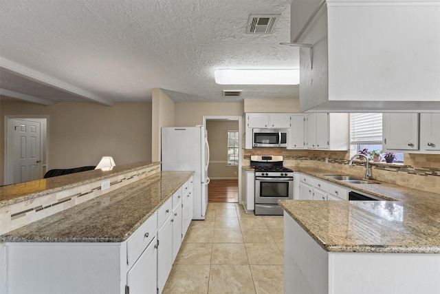 9602 Philmont Dr, Houston, TX 77080 - kitchen with stainless steel appliances, a peninsula, tasteful backsplash, plenty of natural light, and a textured ceiling