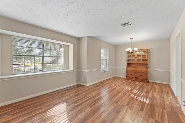 9602 Philmont Dr, Houston, TX 77080 - spare room with a chandelier, wood finished floors, and a textured ceiling