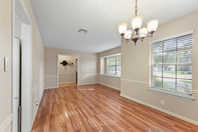9602 Philmont Dr, Houston, TX 77080 - unfurnished room featuring a chandelier, light wood finished floors, and a textured ceiling