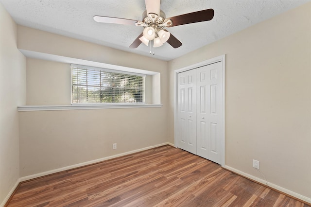 9602 Philmont Dr, Houston, TX 77080 - unfurnished bedroom with wood finished floors, a closet, ceiling fan, and a textured ceiling