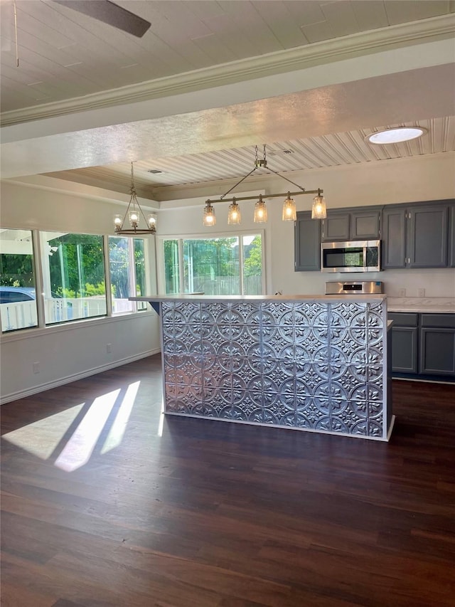 717 W Brazos St, Freeport, TX 77541 - kitchen featuring stainless steel microwave, gray cabinets, ornamental molding, dark wood-style floors, and a chandelier