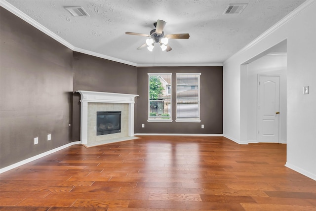 7402 Hollister Rdg, Houston, TX 77040 - unfurnished living room featuring ceiling fan, a textured ceiling, wood finished floors, a tile fireplace, and crown molding