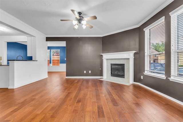 7402 Hollister Rdg, Houston, TX 77040 - unfurnished living room featuring wood-type flooring, a ceiling fan, a tiled fireplace, and ornamental molding