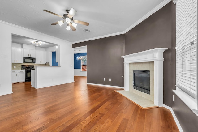 7402 Hollister Rdg, Houston, TX 77040 - unfurnished living room featuring ceiling fan, a fireplace, wood finished floors, and ornamental molding