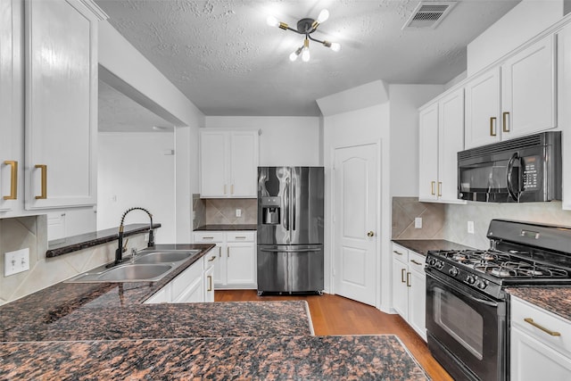 7402 Hollister Rdg, Houston, TX 77040 - kitchen featuring black appliances, wood finished floors, tasteful backsplash, white cabinets, and a textured ceiling