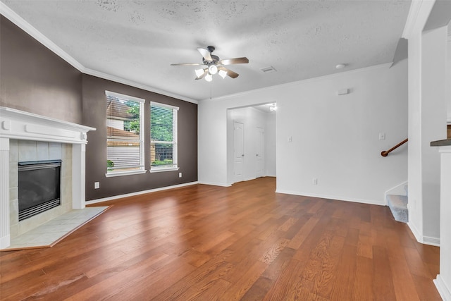 7402 Hollister Rdg, Houston, TX 77040 - unfurnished living room with a ceiling fan, crown molding, a textured ceiling, wood finished floors, and a tile fireplace
