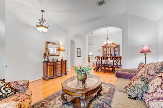 17906 Keenan Cv, Houston, TX 77084 - living room with arched walkways, a chandelier, light wood-type flooring, and vaulted ceiling
