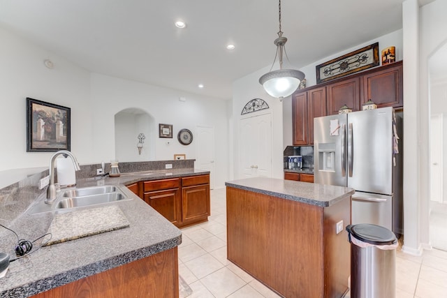 17906 Keenan Cv, Houston, TX 77084 - kitchen featuring stainless steel fridge with ice dispenser, arched walkways, light tile patterned flooring, a center island, and recessed lighting