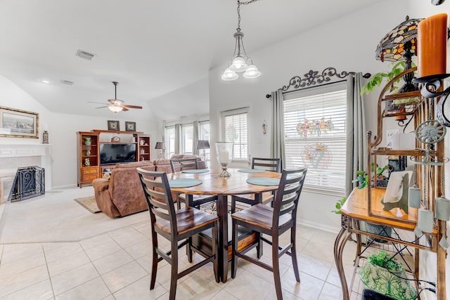 17906 Keenan Cv, Houston, TX 77084 - dining space featuring light tile patterned floors, a tiled fireplace, a ceiling fan, vaulted ceiling, and light colored carpet