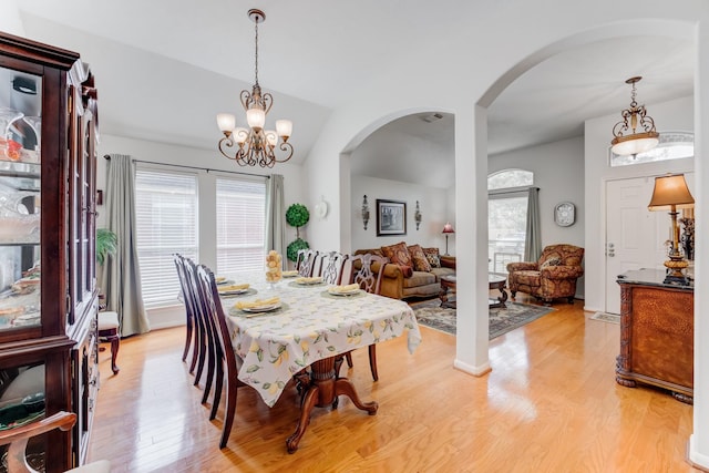 17906 Keenan Cv, Houston, TX 77084 - dining room featuring arched walkways, light wood finished floors, a chandelier, and lofted ceiling