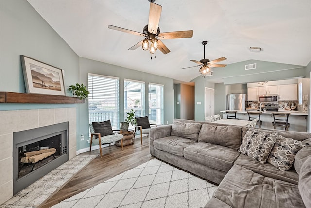 4023 Spanish Main Blvd, Galveston, TX 77554 - living area featuring vaulted ceiling, light wood-style floors, ceiling fan, and a tile fireplace