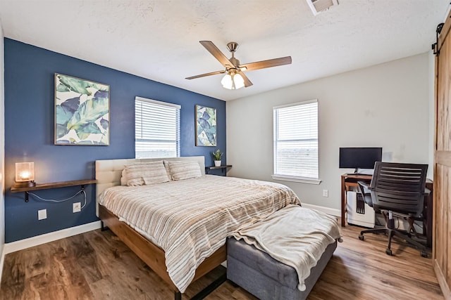 4023 Spanish Main Blvd, Galveston, TX 77554 - bedroom featuring multiple windows, wood finished floors, a ceiling fan, and a barn door