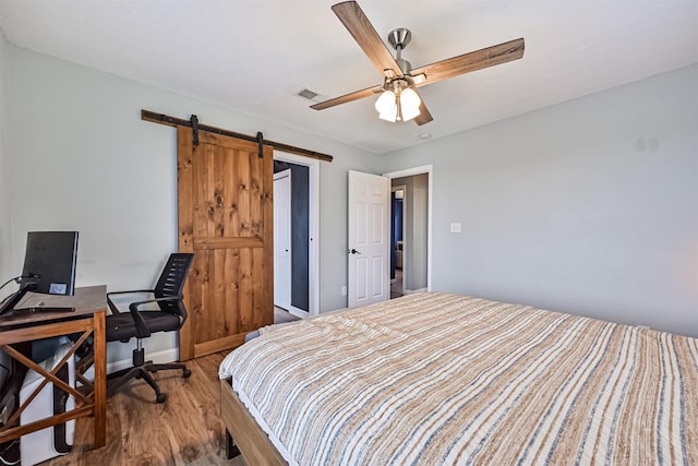 4023 Spanish Main Blvd, Galveston, TX 77554 - bedroom with a barn door, wood finished floors, and a ceiling fan