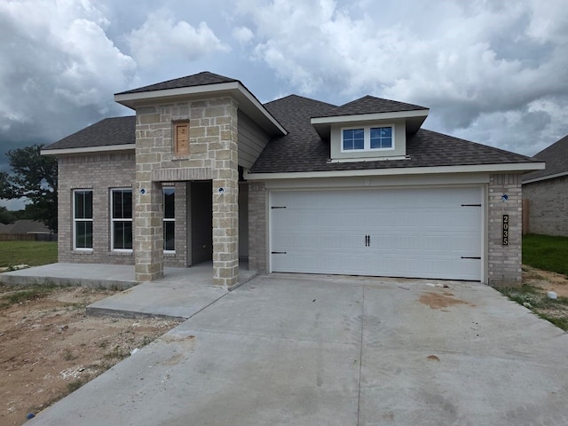 2035 Winepress Rd, Brenham, TX 77833 - view of front of property featuring concrete driveway, a shingled roof, an attached garage, and stone siding