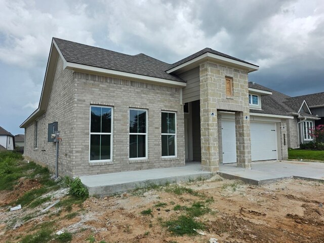 2035 Winepress Rd, Brenham, TX 77833 - view of front of property with a shingled roof, driveway, brick siding, and an attached garage