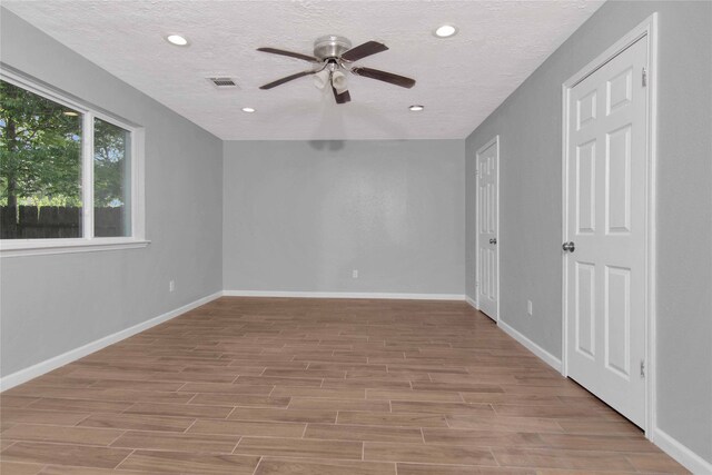 12811 Golden Tee Ln, Houston, TX 77099 - unfurnished room featuring ceiling fan, light wood finished floors, a textured ceiling, and recessed lighting