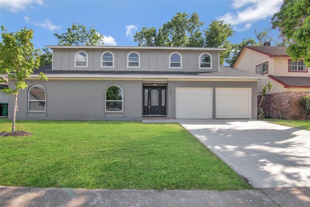 12811 Golden Tee Ln, Houston, TX 77099 - front of property with a front yard, driveway, a garage, brick siding, and a shingled roof