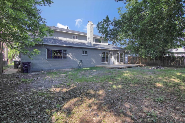 12811 Golden Tee Ln, Houston, TX 77099 - rear view of property with a chimney, a wooden deck, and brick siding