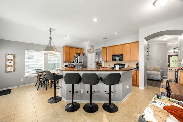 3015 Crescent Oaks Park Ln, Spring, TX 77386 - kitchen featuring black microwave, stove, stainless steel fridge with ice dispenser, arched walkways, and light tile patterned floors