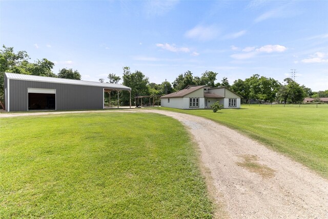 500 E Main St, Clute, TX 77531 - view of front facade with driveway, a pole building, an outdoor structure, a front lawn, and a detached garage
