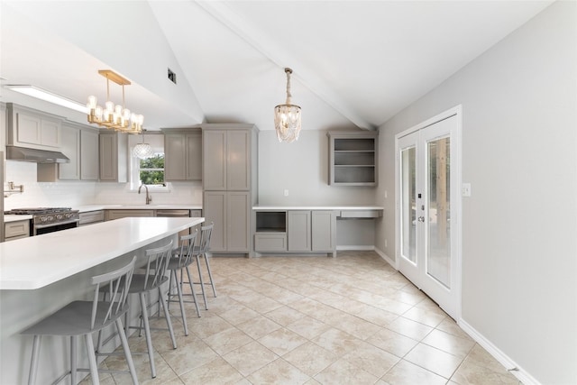 500 E Main St, Clute, TX 77531 - kitchen featuring gray cabinetry, gas range, vaulted ceiling, a chandelier, and decorative backsplash