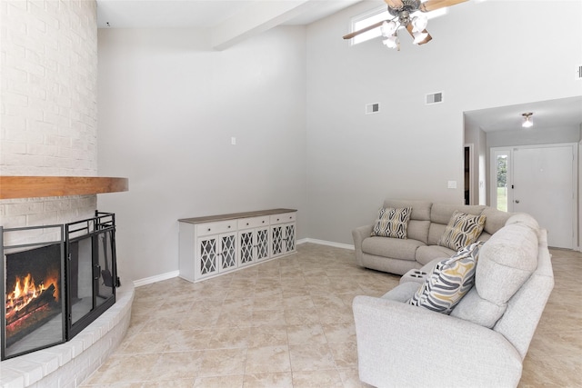500 E Main St, Clute, TX 77531 - tiled living room featuring ceiling fan, a towering ceiling, healthy amount of natural light, and a fireplace