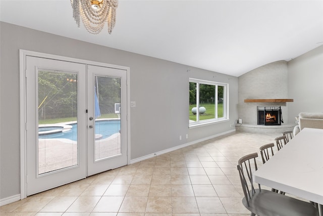 500 E Main St, Clute, TX 77531 - living area with french doors, plenty of natural light, vaulted ceiling, a warm lit fireplace, and light tile patterned flooring