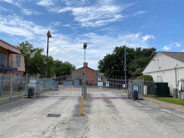 6201 Ranchester Dr Unit 48, Houston, TX 77036 - view of asphalt road with a gate, street lighting, and a gated entry