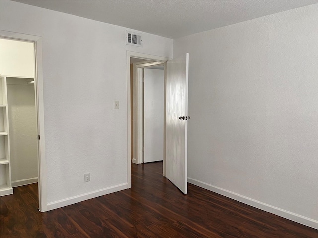 6201 Ranchester Dr Unit 48, Houston, TX 77036 - unfurnished bedroom featuring dark wood-style flooring, a closet, and a walk in closet