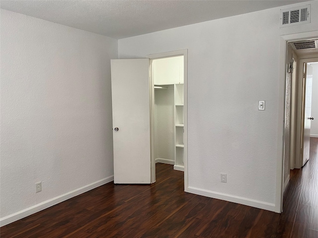 6201 Ranchester Dr Unit 48, Houston, TX 77036 - unfurnished bedroom featuring a walk in closet, dark wood finished floors, and a closet