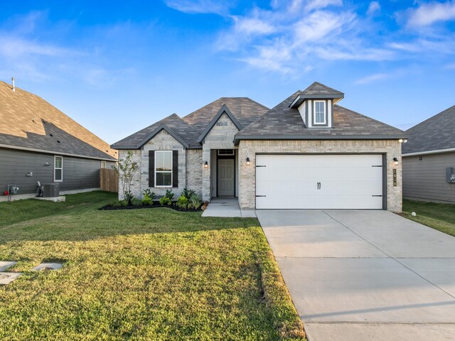 1418 Lake Ridge Dr, Brenham, TX 77833 - view of front of home with a front yard, an attached garage, concrete driveway, and brick siding