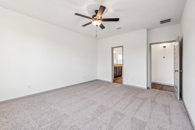 1418 Lake Ridge Dr, Brenham, TX 77833 - unfurnished bedroom featuring light colored carpet, ensuite bathroom, and a ceiling fan
