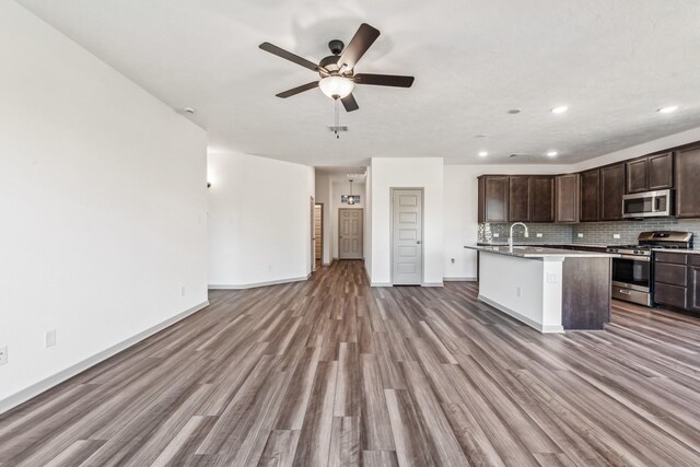 1418 Lake Ridge Dr, Brenham, TX 77833 - kitchen featuring appliances with stainless steel finishes, open floor plan, light wood-style flooring, dark brown cabinetry, and a ceiling fan