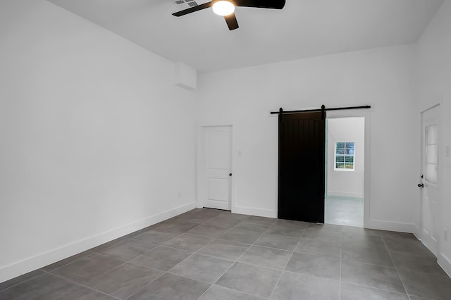 17128 Spindle Oaks Dr, Conroe, TX 77385 - tiled empty room featuring a barn door and ceiling fan