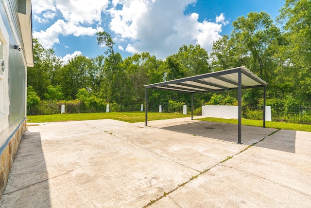17128 Spindle Oaks Dr, Conroe, TX 77385 - view of patio / terrace featuring a carport, concrete driveway, and view of wooded area