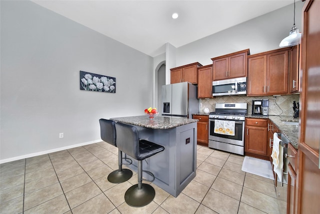 506 Glenwood Ridge Dr, Spring, TX 77386 - kitchen featuring appliances with stainless steel finishes, a kitchen breakfast bar, decorative backsplash, a center island, and light tile patterned floors