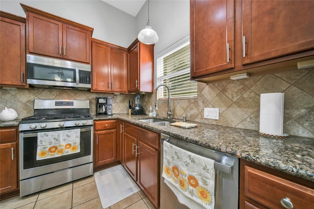 506 Glenwood Ridge Dr, Spring, TX 77386 - kitchen with appliances with stainless steel finishes, dark stone counters, light tile patterned floors, and tasteful backsplash
