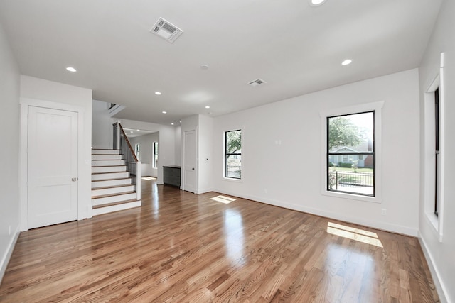 4541 Walker St, Houston, TX 77023 - unfurnished living room with stairway, light wood-style floors, and recessed lighting
