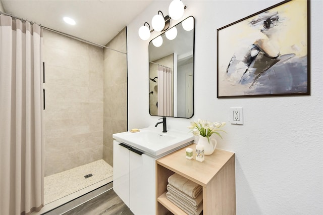 5817 Beechnut St, Houston, TX 77074 - full bath with vanity, tiled shower, wood finished floors, and recessed lighting